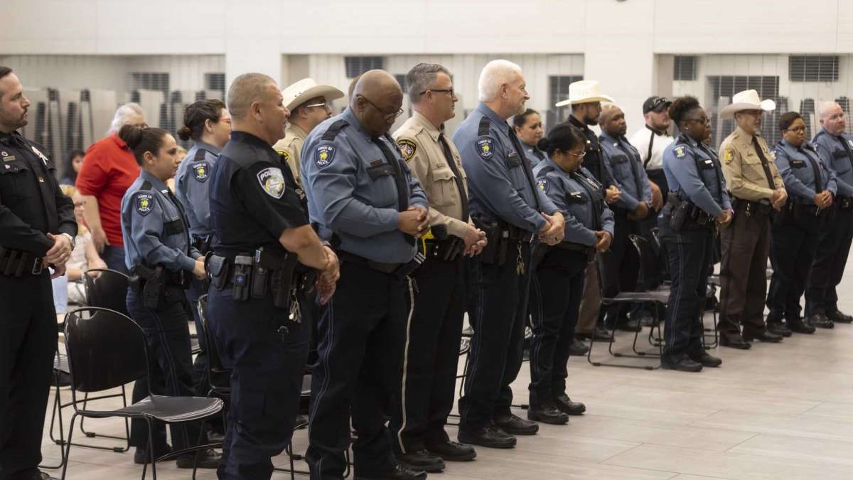 Officers with Conroe ISD Police partake in a prayer during a graduation ceremony from training with the D.A.R.E. program at Stockton Junior High School, Friday, June 18, 2021, in Conroe. The program lasted approximately two weeks.