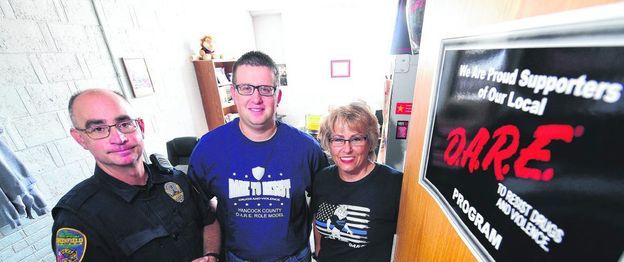 New D.A.R.E. officer Kyle Addison, middle, is flanked by colleagues Steve McCarley of the Greenfield Police Department, left; and Christine Rapp, the leader of the program. The addition of Addison to the D.A.R.E. team will allow it to expand the program's reach, Rapp said. (Tom Russo | Daily Reporter)
